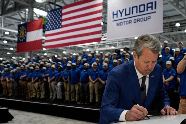Georgia Gov. Brian Kemp signs a IONIQ 9 EV vehicle during a media tour and grand opening at the Hyundai Motor Group Metaplant America, Wednesday, March 26, 2025, in Ellabell, Ga. (AP Photo/Mike Stewart)