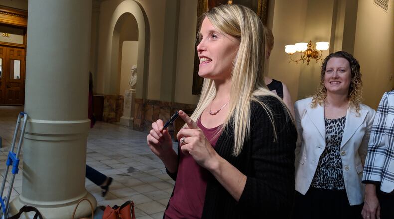 May 8, 2018, Atlanta -- Child sexual abuse survivor Erin Merryn, of Illinois, encouraged Rep. Wes Cantrell, R-Woodstock, to write a new law requiring schools to teach students starting in kindergarten about sexual abuse. She shows the pen Gov. Nathan Deal had just used to sign Senate Bill 401 into law at the Gold Dome.