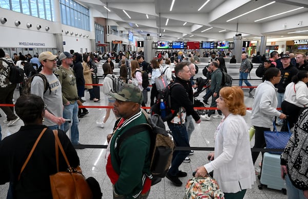 Early morning travelers waited in long lines extending to the baggage claim area to get through security screening at Hartsfield-Jackson Atlanta International Airport on Saturday, March 21, 2026, amid the partial government shutdown. (Hyosub Shin/AJC)