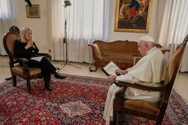 FILE - Pope Francis looks at a picture given to him by Associated Press correspondent Nicole Winfield during an interview at the Vatican, on Jan. 24, 2023. (AP Photo/Andrew Medichini, File)