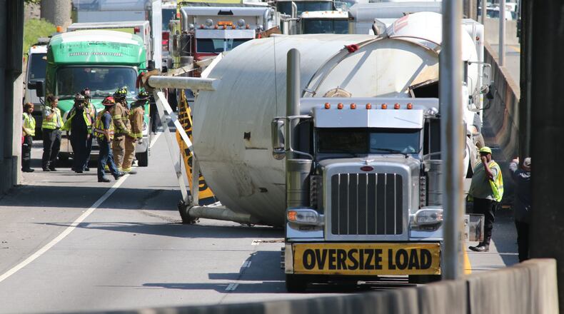 A tan being hauled on a trailer landed on the southbound lanes of the Buford-Spring Connector Tuesday. (Photo: John Spink/ajc.com)
