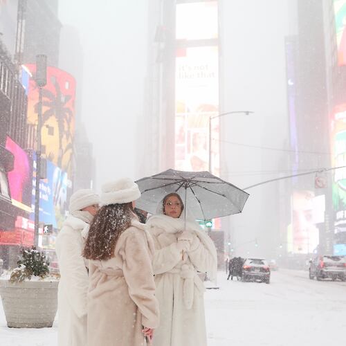 People wait to cross the street in Times Square during a winter storm, Sunday, Jan. 25, 2026, in New York. (AP Photo/Heather Khalifa)
