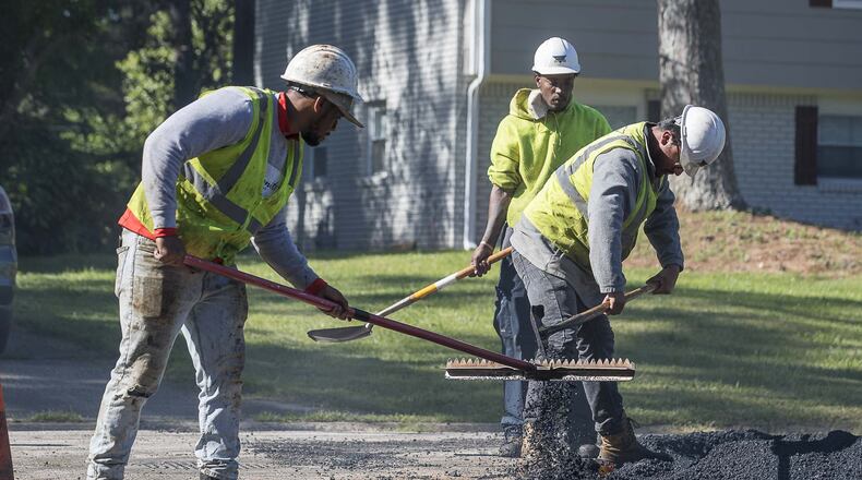 04/16/2020 - Decatur, Georgia - An H.E.H. Paving crew works to lay asphalt on Gwendon Terrace in Decatur, Thursday, April 16, 2020. The paving project is part of the DeKalb County Special Purpose Local Option Sales Tax or SPLOST. (ALYSSA POINTER / ALYSSA.POINTER@AJC.COM)