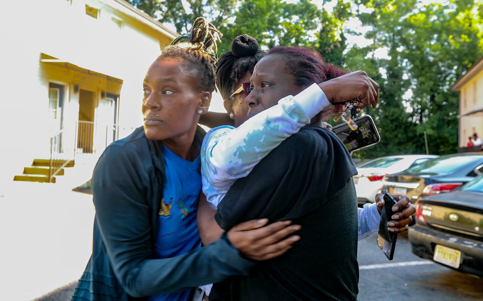 Mother of two of three missing children, Britshonna McDaniel (center) embrace grandmothers Tadasha Wise (center) and Alkini Patterson (right) after learning Atlanta police found the 3-missing children on Friday morning, June 2, 2023 in Northwest Atlanta. Britshonna McDaniel felt the weight of the world lift when a news reporter nodded yes to her question: "Did they find them?" Her two children and their cousin had been missing for 18 hours after they wandered away from their northwest Atlanta neighborhood park Thursday afternoon. The 6-year-old, 10-year-old and 14-year-old were found safe at a friend's house at about 9 a.m. Friday.  (John Spink / John.Spink@ajc.com)

