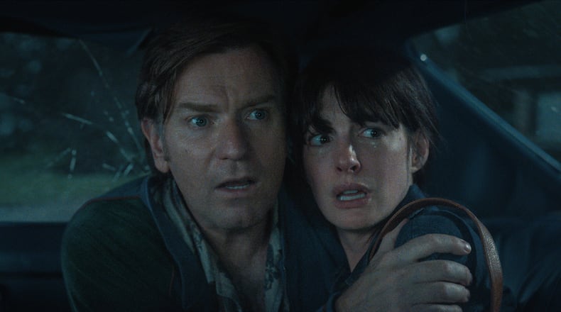 Ewan McGregor and Anne Hathaway inside a car trying to avoid a dinosaur in the sci-fi adventure "The End of Oak Street" shot in the Wisteria Gardens neighborhood of Southwest Atlanta in 2024. (Courtesy of Warner Brothers)