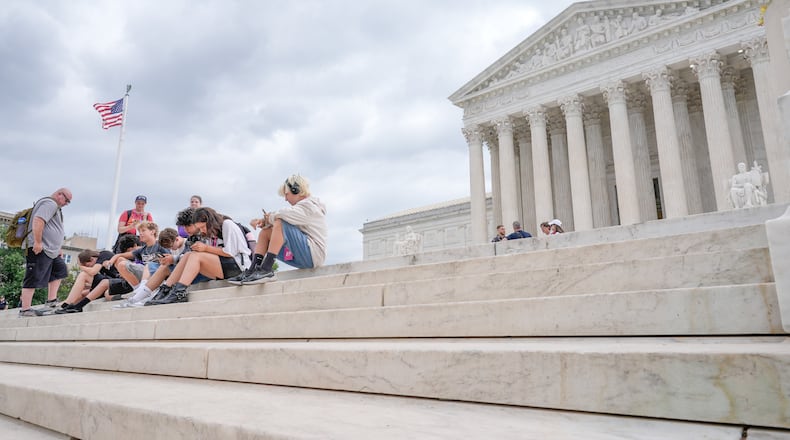 Visitors sit on the steps of the U.S. Supreme Court, Monday, June 8, 2026, in Washington. (AP Photo/Mariam Zuhaib)