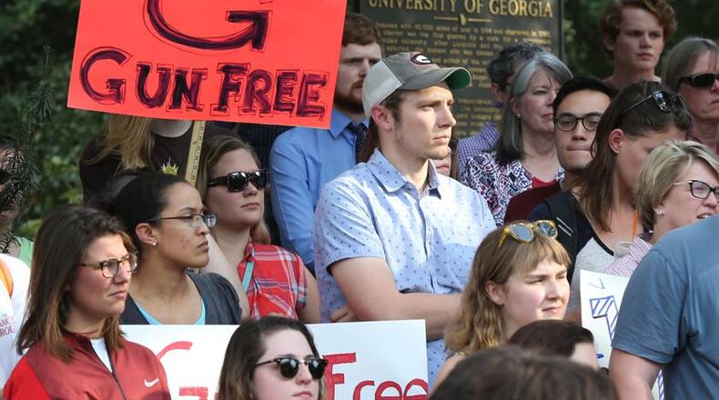 Students, faculty, staff and local residents hold a protest against campus carry legislation at the University of Georgia Arch in Athens. Curtis Compton/ccompton@ajc.com