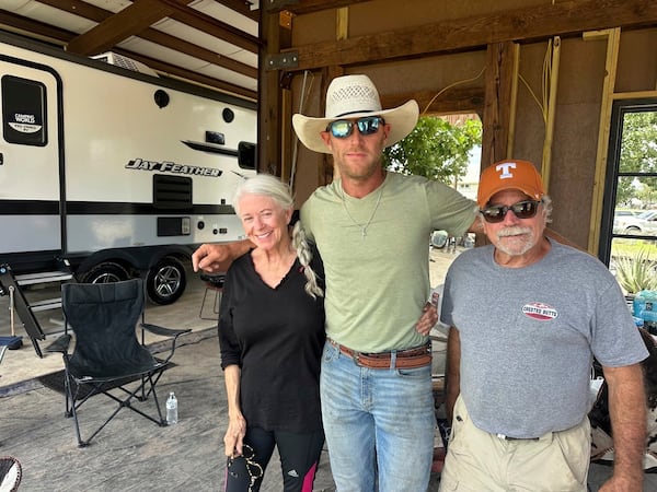 Flood survivors Elizabeth Hastings, left, and Paul Welch, right, stand with volunteer Huntly Dantzler in Comfort, Texas, on Saturday, July 12, 2025. (AP Photo/Gabriela Aoun Angueira)