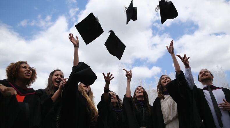 Students throw their caps in the air ahead of their graduation ceremony. (Photo by Dan Kitwood/Getty Images)