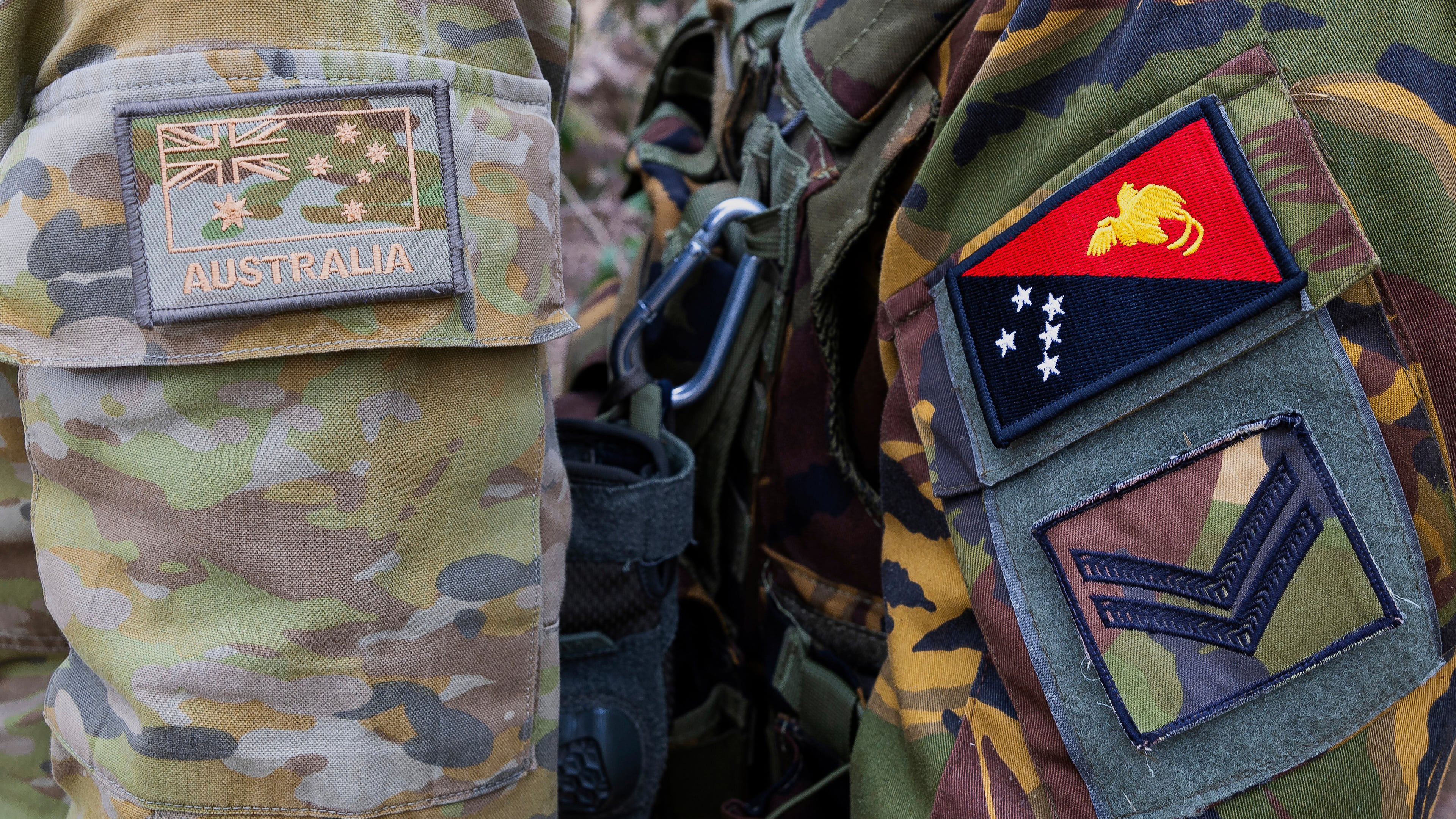 This photo shows the emblem of an Australian Army soldier, left, and a Papua New Guinea Defence Force soldier during an exercise at Talisman Sabre in Townsville, Australia, on July 21, 2025. (LCPL Jessica Gray/Australian Army via AP)