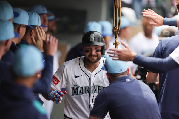 Seattle Mariners designated hitter Cal Raleigh celebrates in the dugout after hitting a solo home run during the sixth inning of a baseball game against the Pittsburgh Pirates, Friday, July 4, 2025, in Seattle. (AP Photo/Ryan Sun)
