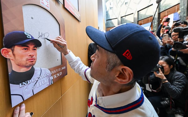 FILE - Newly-elected Baseball Hall of Fame member Ichiro Suzuki signs the backer board where his plaque will hang during a news conference Thursday, Jan. 23, 2025, in Cooperstown, N.Y. (AP Photo/Hans Pennink, File)