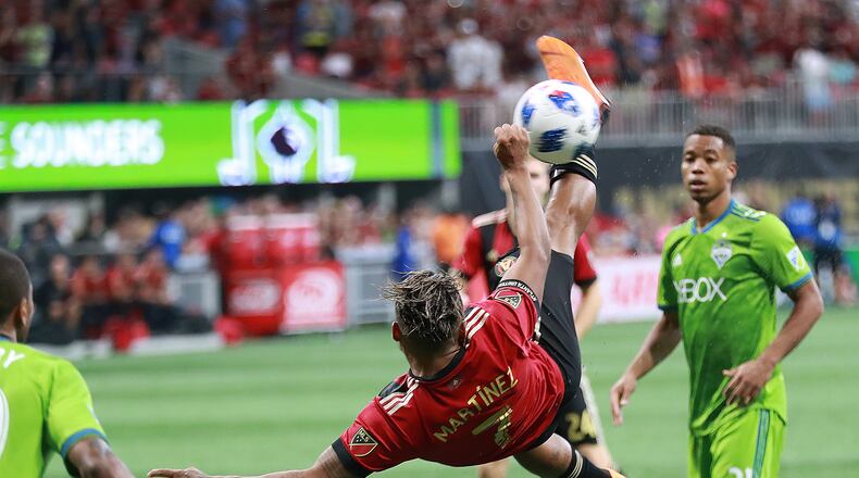Atlanta United striker Josef Martinez attempts a bicycle kick against the Seattle Sounders that goes wide with Jordy Delem looking on during the second half in a MLS soccer game on Sunday, July 15, 2018, in Atlanta. Martinez scored his team’s only goal in a 1-1 tie.     Curtis Compton/ccompton@ajc.com