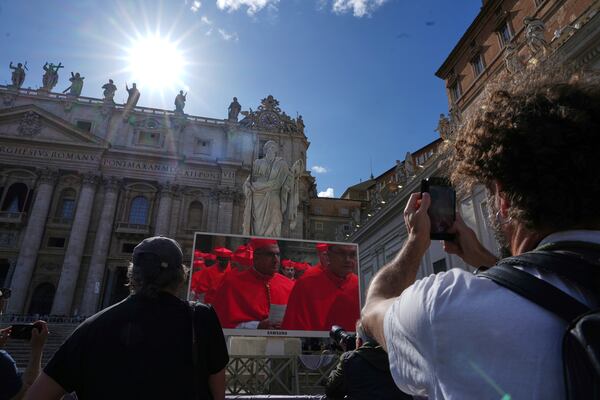 Faithful watch a giant screen showing images of cardinals entering the conclave, in St. Peter's Square at the Vatican, Wednesday, May 7, 2025. (AP Photo/Andrew Medichini)