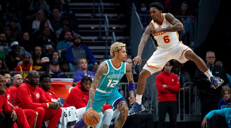 Atlanta Hawks guard Lou Williams (6) defends against Charlotte Hornets guard Kelly Oubre Jr. (12) during the second half of an NBA basketball game Wednesday, March 16, 2022, in Charlotte, N.C. (AP Photo/Matt Kelley)