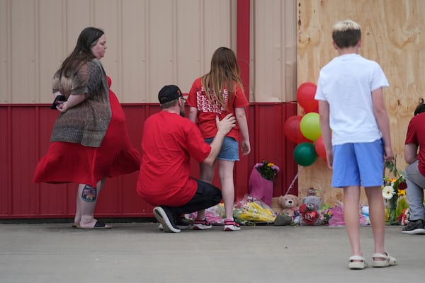 People leave balloons at the scene where a car barreled through a building used for an after-school camp Tuesday, April 29, 2025, in Chatham, Ill. (AP Photo/Erin Hooley)