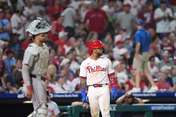 Philadelphia Phillies' Edmundo Sosa, right, and Boston Red Sox catcher Carlos Narváez wait for umpires to make a catcher's interference call with the bases loaded during the 10th inning of a baseball game Monday, July 21, 2025, in Philadelphia. (AP Photo/Matt Slocum)