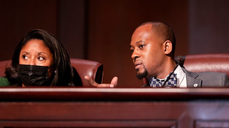 Council members Marci Collier Overstreet (left) and Antonio Lewis confer as the Atlanta City Council held their first in person meeting since they were suspended at start of the pandemic In Atlanta on Monday, March 21, 2022. (Bob Andres / robert.andres@ajc.com)