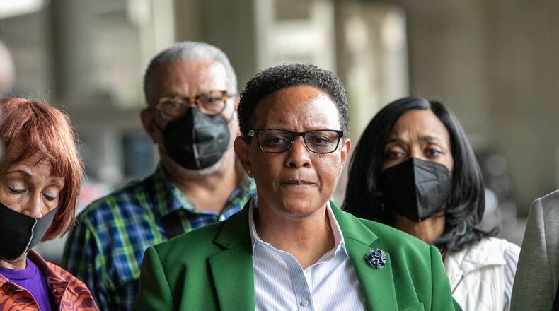 Rev Mitzi Bickers (green blazer) is found guilty on all but three charges at the Richard B Russell Federal Courthouse on Wednesday, March 23, 2022.  Bickers is surrounded by friends, family and her attorney Drew Findling (dark sunglasses) as she leaves the courthouse.  Sentencing is scheduled for July 12.  (Jenni Girtman for The Atlanta Journal-Constitution)