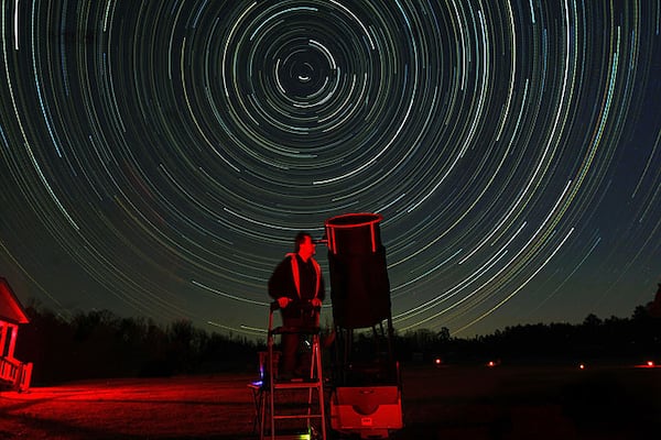 Star trails streak through the sky as Dan Llewellyn, 46, Decatur, lines up his 20-inch Star Master telescope to photograph Mars and Saturn outside his cabin at the Deerlick Astronomy Village in Sharon on Friday, March 19, 2010. The "Star Trails" in the sky are created by the movement of the earth during a 5-hour time exposure while the photographer's camera remains fixed on a tripod.