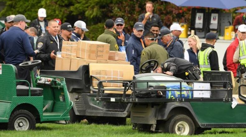 The golf cart that injured five people Friday is inspected by spectators during Friday's second round of the U.S. Open.