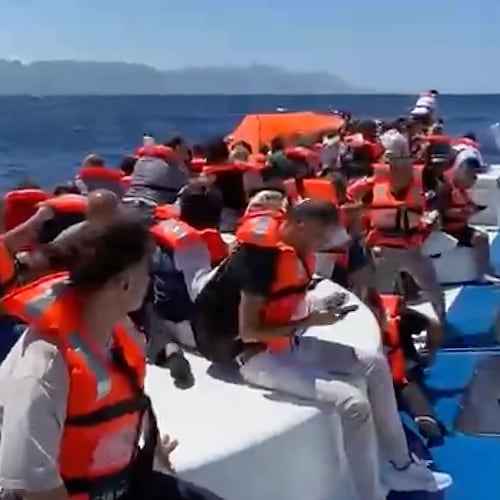 In this frame grab from a video, passengers wearing life jackets wait atop a capsized passenger vessel to be rescued off the coast of Girne, in the Turkish-occupied northern part of Cyprus, Sunday, Aug. 30, 2026. (DHA via AP)