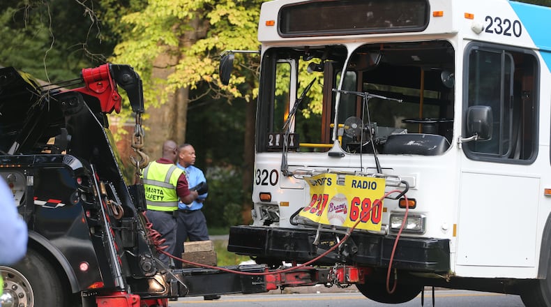 A MARTA bus is hauled away after it was hit by a vehicle that reportedly ran a stop sign at the intersection of Delowe Drive and Woodbury Avenue. (BEN GRAY / BGRAY@AJC.COM)