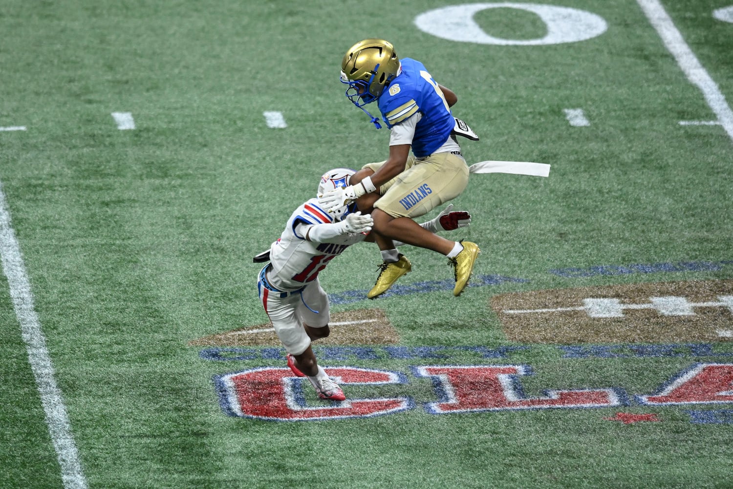 McEachern’s Casey Barner (6) leaps over Walton defensive end Cj Jordan (12) as gains yardage during the second half of the Corky Kell Classic football game Saturday, August 16, 2025 at the Mercedes-Benz Stadium. (Daniel Varnado/For the Atlanta Journal-Constitution)