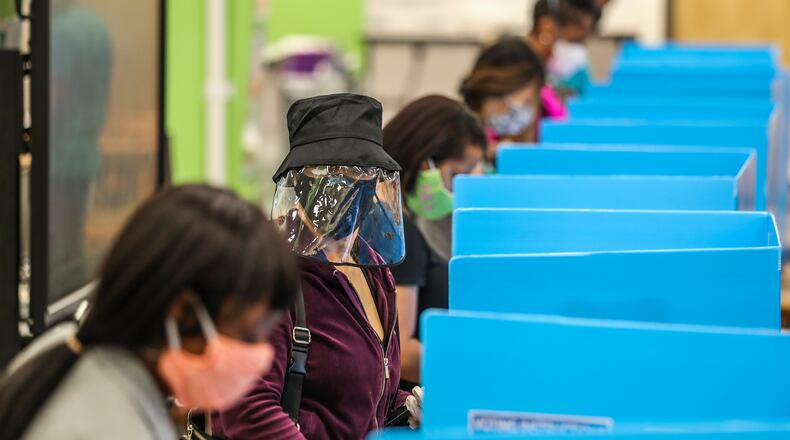 C.K. Hoffler, center, wore a face shield as she voted in Tuesday’s Georgia primary at Cross Keys High School in DeKalb County. JOHN SPINK/JSPINK@AJC.COM