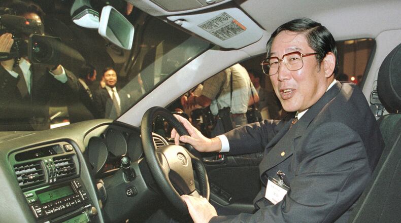 FILE - Hiroshi Okuda, then, president of Toyota Motor Corp., smiles as he sits at the steering wheel of the "Aristo," Toyota's remodeled sports sedan during a press conference at a Tokyo hotel, Aug. 27, 1997. (AP Photo/Shizuo Kambayashi, File)