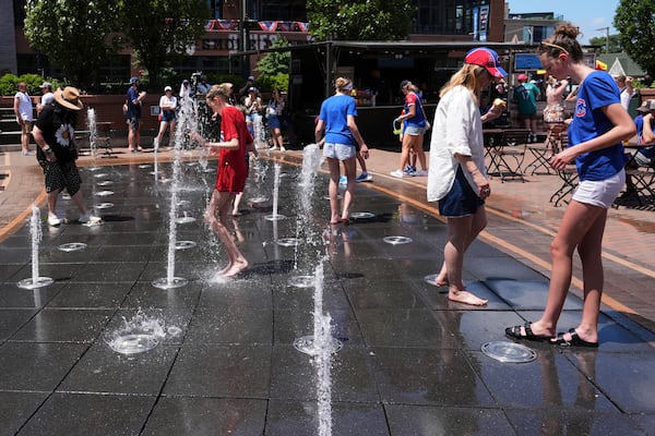 People cool off at a fountain during hot weather in Chicago, Sunday, June 22, 2025. (AP Photo/Nam Y. Huh)