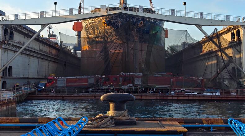 In this photo released by Xinhua News Agency, firefighters' vehicles parked near a repair cargo ship after it caught fire at a port in Qingdao, east China's Shandong Province, Thursday, Sept. 10, 2026. (Li Aoqiu/Xinhua via AP)