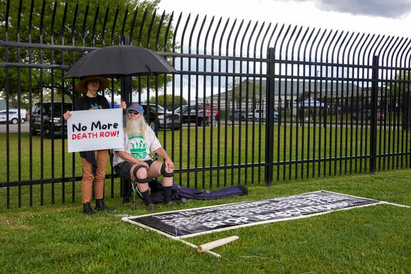 Protestors Noel Nickel, left, and Ron Kaz demonstrate in the rain outside the scheduled execution of South Carolina inmate Mikal Mahdi in Columbia, S.C., Friday, April 11, 2025. (AP Photo/David Yeazell)
