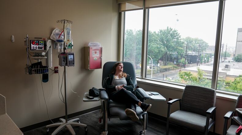 Emily Domhoff, diagnosed in her late 20s with colon cancer, sits in June with a saline drip IV after having her chemotherapy infusion pump removed. MUST CREDIT: Jahi Chikwendiu/The Washington Post