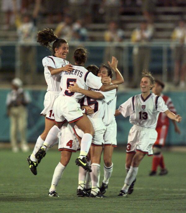 The U.S. women's soccer team enjoys a golden moment and jumps for joy as time runs out on their historic 2-1 gold medal win over China at Sanford Stadium in Athens during the 1996 Summer Olympic Games. (David Tulis/AJC)