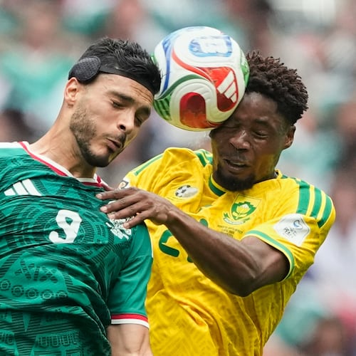 Mexico's Raul Jimenez, left, jumps for the ball with South Africa's Ime Okon during the World Cup Group A soccer match between Mexico and South Africa in Mexico City, Thursday, June 11, 2026. (AP Photo/Natacha Pisarenko)