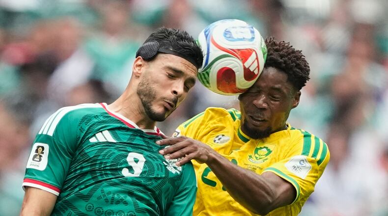 Mexico's Raul Jimenez, left, jumps for the ball with South Africa's Ime Okon during the World Cup Group A soccer match between Mexico and South Africa in Mexico City, Thursday, June 11, 2026. (AP Photo/Natacha Pisarenko)