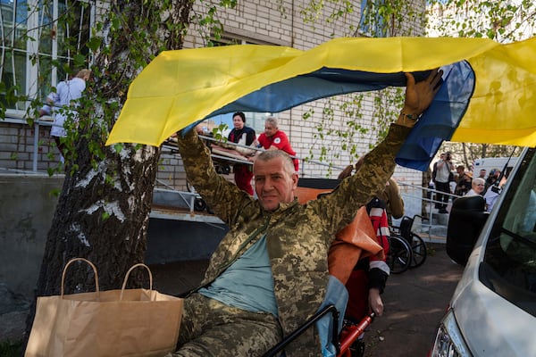 An injured Ukrainian soldier waves a national flag after returning from captivity in a POW exchange in Ukraine, on Saturday, April. 19, 2025. (AP Photo/Evgeniy Maloletka)