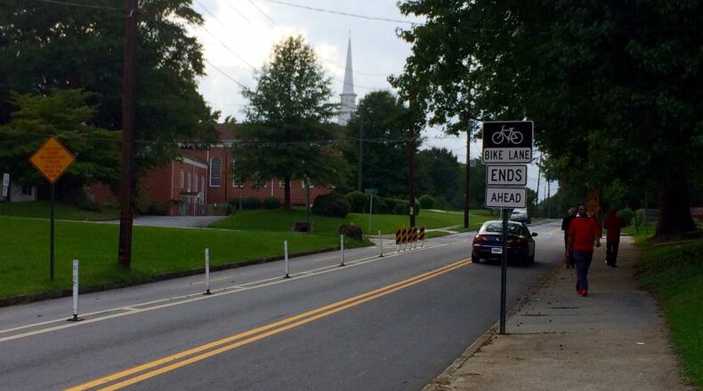 A sign warns bicyclists that a protected bike lane is about to end. A church in Atlanta requested removal of some of the lanes, saying they obstructed the congregation driving in and out. Others saw it as a sign of gentrification. (Photo by Bill Torpy)