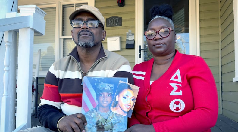 Oneida Oliver-Sanders, right, and Shawn Sanders hold a photograph of their daughter, Sgt. Kennedy Ladon Sanders, at their Waycross GA home Tuesday, January 30, 2024. (Joe Kovac/ Joe.Kovac@ajc.com)