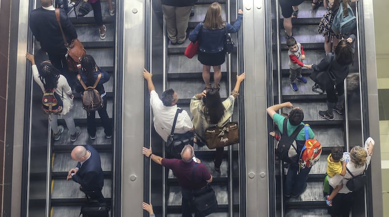 Hartsfield-Jackson International Airport received high marks from an online travel site, which said that Atlanta’s airport will be the country’s busiest over Labor Day weekend, but will have the fewest delays. Here crowds move up the escalator from arriving planes on the domestic side. JOHN SPINK/JSPINK@AJC.COM.