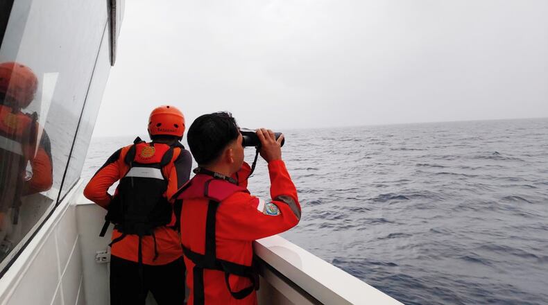 In this photo released by Makassar Search and Rescue Office on Sunday, July 19, 2026, rescuers scan the horizon as they search for victims after a passenger boat sank in the waters near Selayar Islands in South Sulawesi, Indonesia. (Makassar SAR Office via AP)
