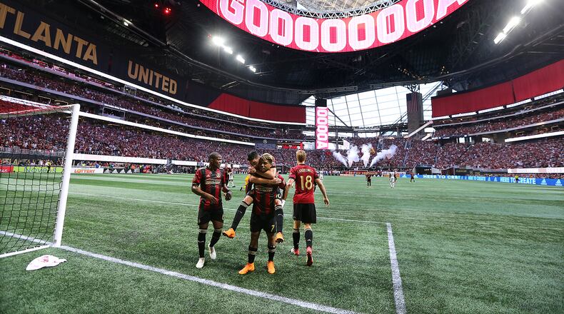 June 2, 2018 Atlanta: The roof of Mercedes-Benz Stadium is open as Atlanta United forward Josef Martinez celebrates his goal on a penalty kick with teammates while Miguel Almiron jumps on his back for a 1-0 lead against Philadelphia Union during the first half in a MLS soccer match on Saturday, June 2, 2018, in Atlanta. Curtis Compton/ccompton@ajc.com
