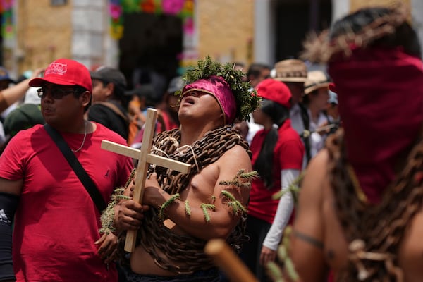A masked penitent, wearing chains and a crown of thorns and cacti attached to his arms, takes part in a Holy Week procession in Atlixco, Mexico, on Good Friday, April 18, 2025. (AP Photo/Eduardo Verdugo)