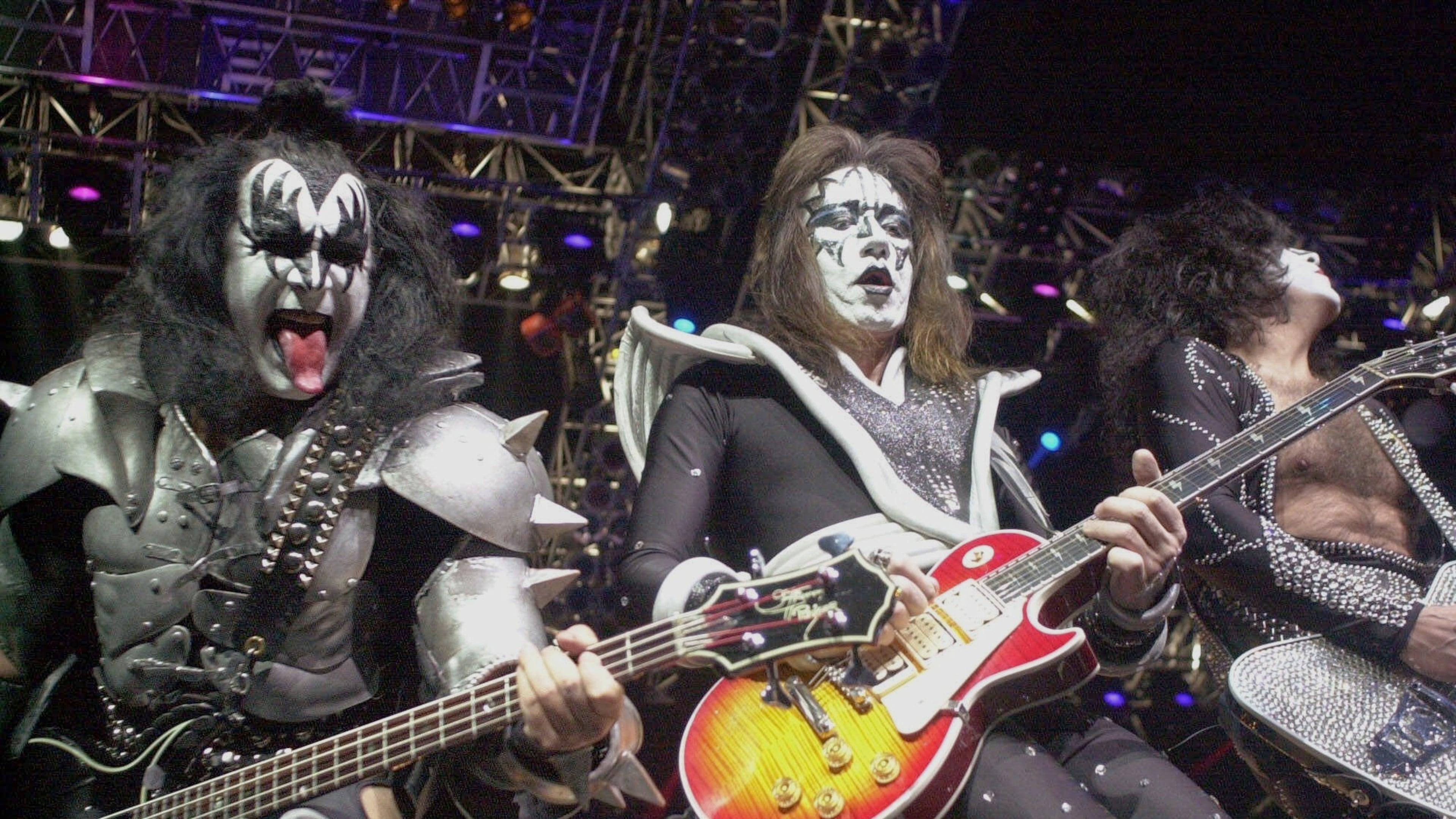 FILE - Kiss guitarist Paul Stanley, right, guitarist Ace Frehley, center, and bassist Gene Simmons play during the band's farewell concert in the Detroit area, Thursday, May 25, 2000, at the Palace of Auburn Hills, Mich.. (AP Photo/Paul Warner, File)