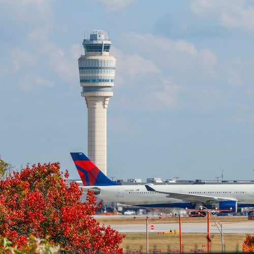 A Delta Air Lines plane passes by the control tower at Hartsfield-Jackson Atlanta International Airport on Sunday, Nov. 9, 2025. Transportation Secretary Sean Duffy warned Friday that flight reductions might continue to increase if the government shutdown persists. (Miguel Martinez/AJC)