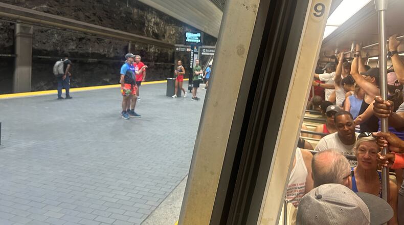 Runners headed to the Peachtree Road Race stand shoulder-to-shoulder on a northbound train leaving Peachtree Center Station around 6:30 a.m. Friday. (Gray Mollenkamp/AJC)