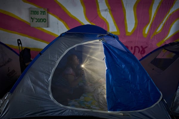 People spend the night in a public shelter as a precaution against possible Iranian missile attacks, in Tel Aviv, Israel, Saturday, June 21, 2025. (AP Photo/Ohad Zwigenberg)