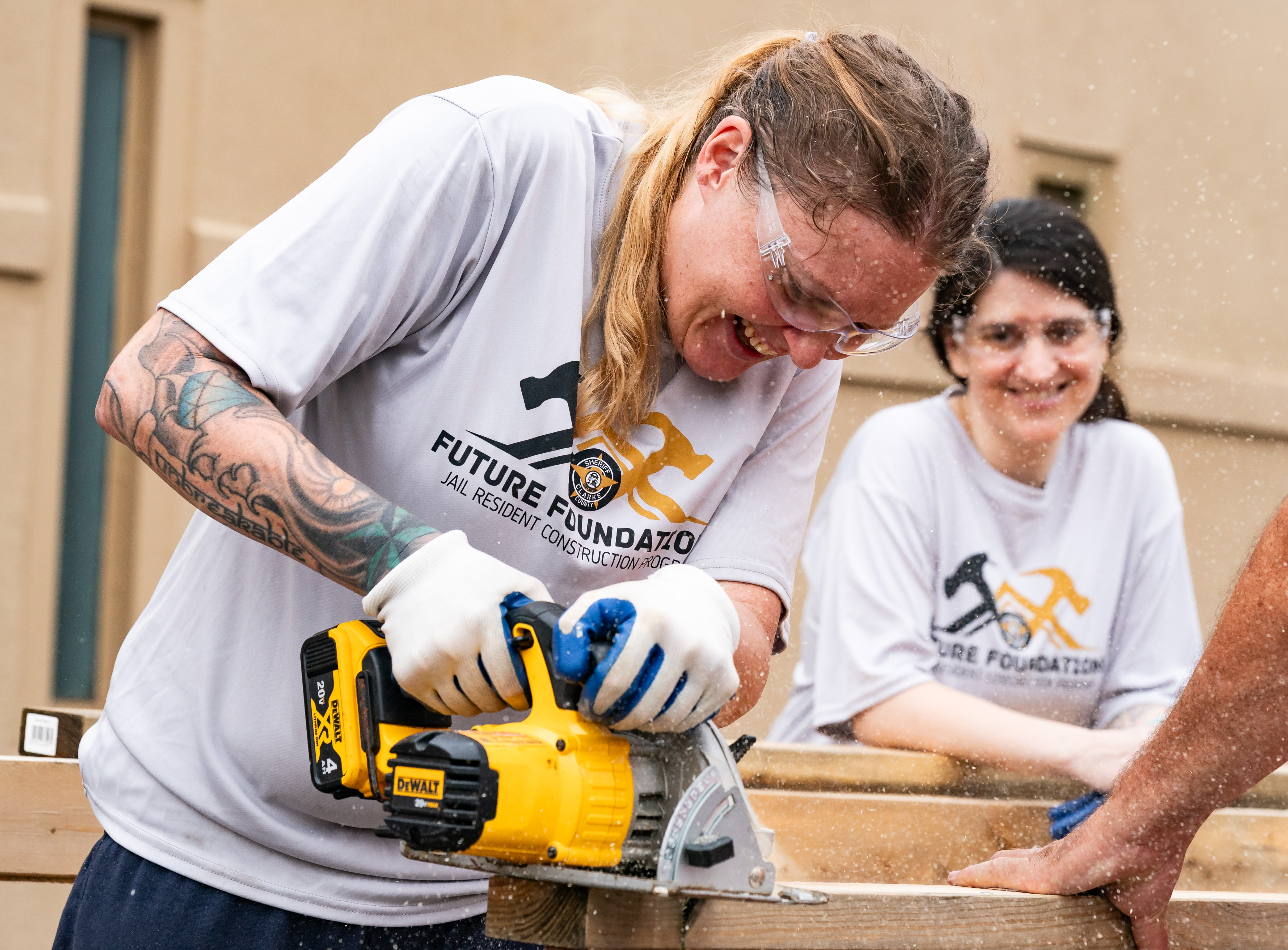 Nichole Mosley, an inmate at the Athens-Clarke County Jail, saws through wood while building a tiny home in the jail yard in Athens. (Seeger Gray/AJC 2024)