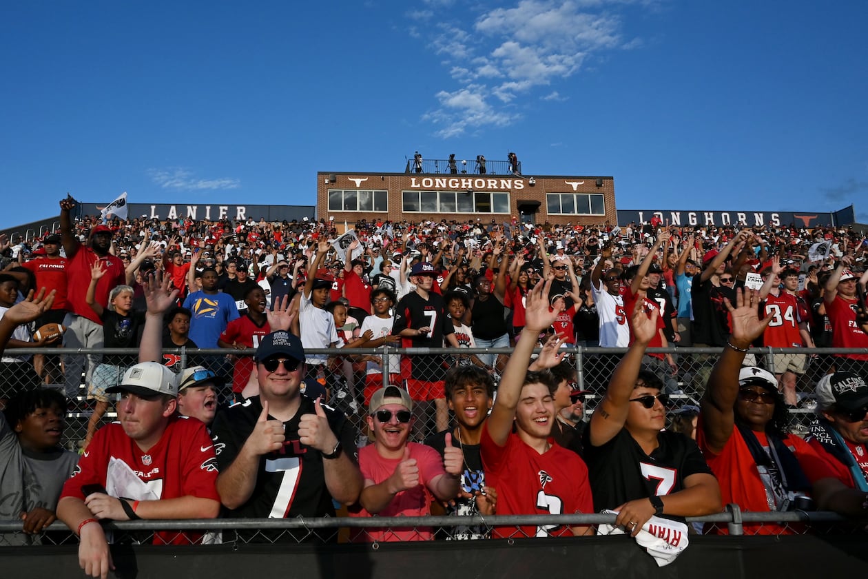 Football fans cheer as they watch the Falcons' "Saturday Night Lights" practice at Lanier High School on Saturday, Aug. 8, 2026, in Sugar Hill. (Hyosub Shin/AJC)